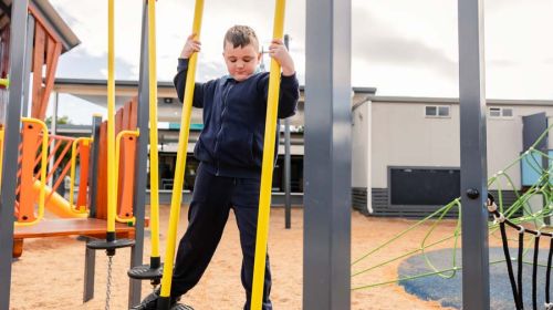 A Junior School student balancing on the play equipment.